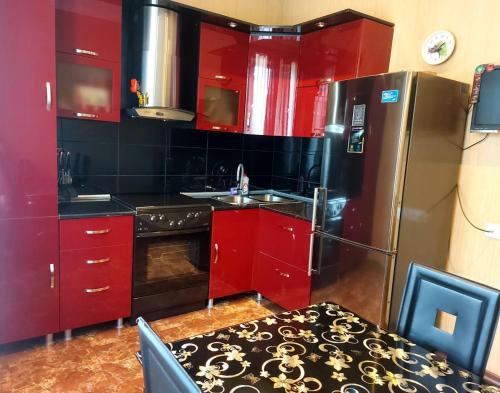 第比利斯GOAL Apartments 2的厨房配有红色橱柜和不锈钢冰箱