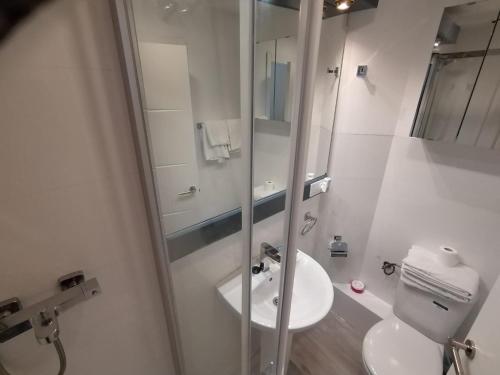 马德里Apartamento para 4 - Puerta del Sol的白色的浴室设有水槽和淋浴。