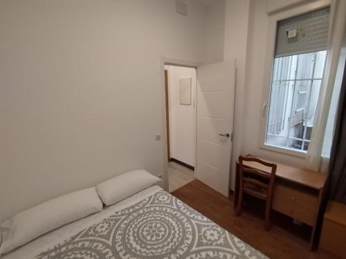 马德里Apartamento para 4 - Puerta del Sol的卧室配有床、椅子和窗户。