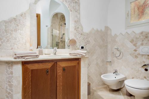 马里内拉Appartamento Eleganza - SHERDENIA Luxury Apartments的一间带水槽、卫生间和镜子的浴室