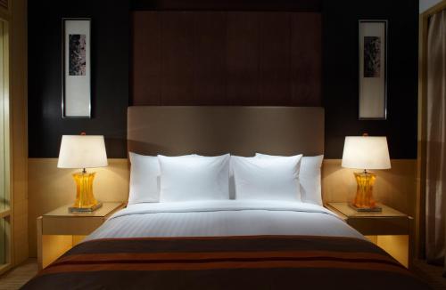 上海上海浦西万怡酒店的一间卧室配有一张大床和两盏灯