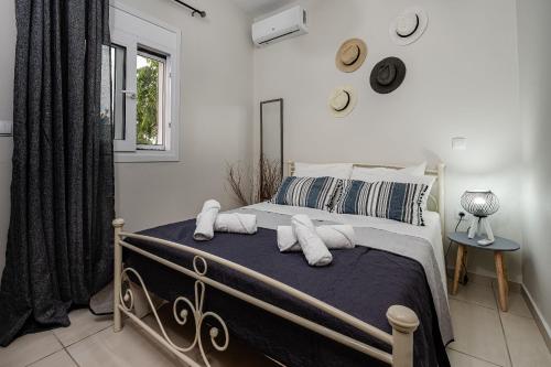 扎金索斯镇Aria Apartment的卧室配有带枕头的床铺和窗户。