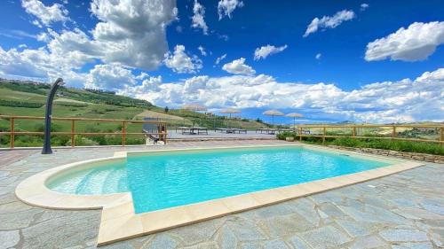 迪亚诺达尔巴Le Cornici - Cascina di Charme的蓝色天空庭院中的游泳池