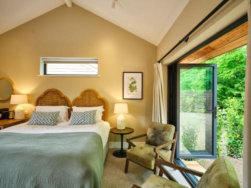 贝里圣埃德蒙兹The Weeping Willow的卧室配有床、椅子和窗户。