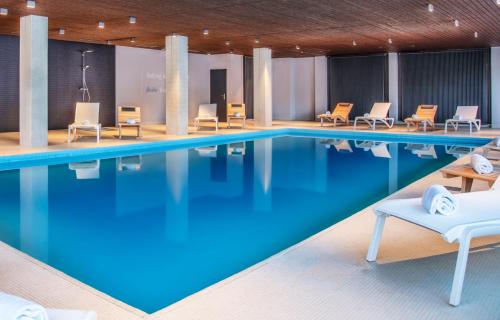 威拉尔-苏-罗伦Victoria Hotel & Residence的一座配有桌椅的酒店游泳池