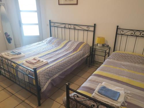 Grazzano BadoglioLocation Turistic Antica dimora di Campagna Cir 00012的一间卧室设有两张单人床和一个窗户。