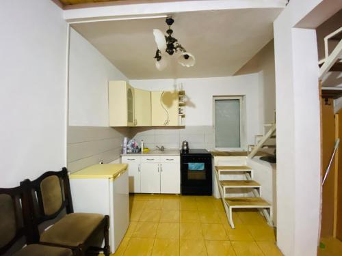 米特罗维察Villat Bardhoshi的厨房配有白色橱柜和桌椅