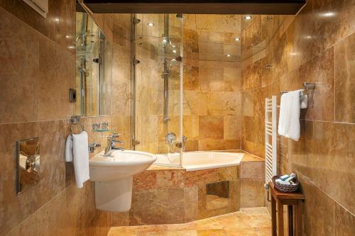 布拉格Hotel U Prince Prague by BHG的浴室配有盥洗盆和浴缸。