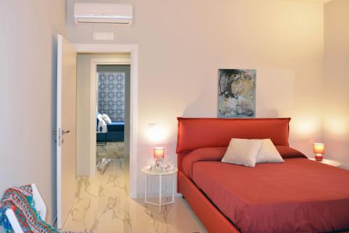 San Corrado di FuoriVilla Pica by PosarelliVillas的一间卧室配有一张红色的床和一张带蜡烛的桌子。