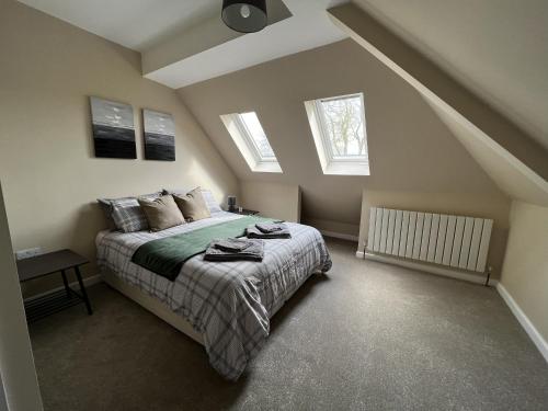 温彻斯特Charming 4-Bed House in Winchester Free Parking的一间卧室设有一张床和两个窗户。