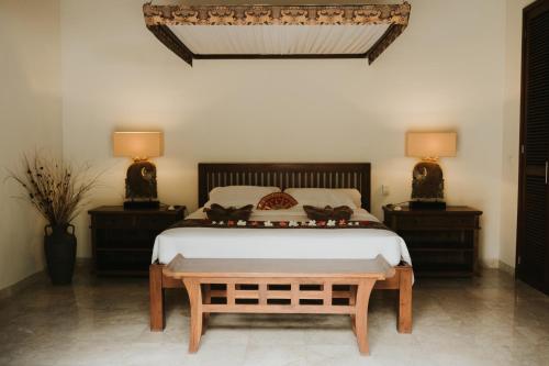 特贾库拉ALOKA BAHARI Villas的一间卧室配有一张带2个床头柜的大床