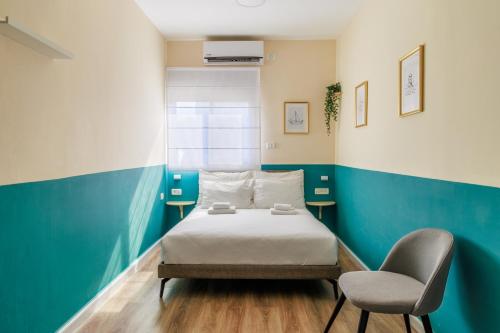海法Domus Bat Galim Hotel的一间卧室配有一张床和一把椅子