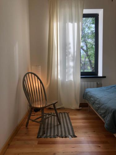 久姆里Cozy house的一张床和一个窗户的房间的椅子