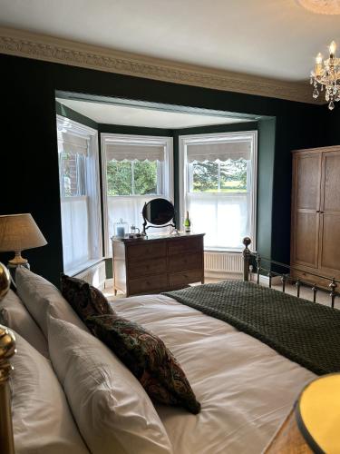 诺里奇The Lodge at Salhouse的一间卧室设有一张大床和两个窗户。