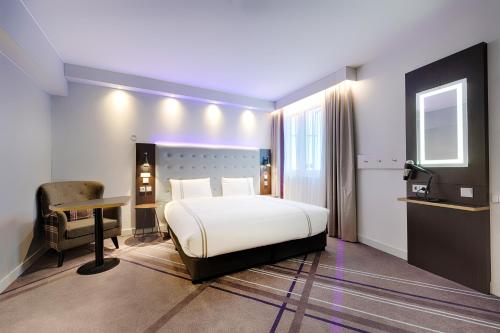 柏林Premier Inn Berlin City Wilmersdorf的一间卧室配有一张床、一张桌子和一把椅子