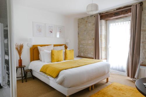 MaisonsFerme des Goupillières的卧室配有一张带黄色枕头的大型白色床。