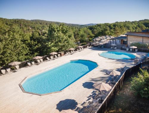 瓦纳斯Village Huttopia Sud Ardèche的享有带遮阳伞的游泳池的顶部景致