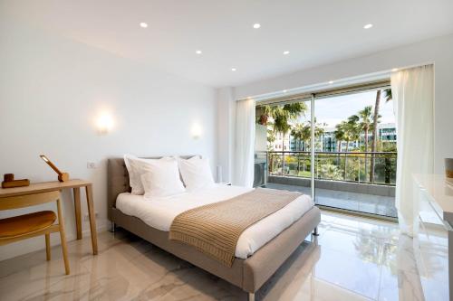 戛纳Agence des Résidences - Appartements privés du 45 CROISETTE- Prestige的一间卧室设有一张床和一个大窗户