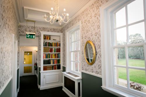 胡克Warbrook House Heritage Hotel的走廊上设有书架和吊灯
