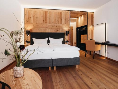Sankt Lorenzen im LesachtalAlmwellness-Resort Tuffbad的一间卧室配有一张大床和一张书桌