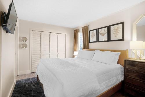 德斯坦Sandpiper Cove 2023的一间白色卧室,配有床和电视
