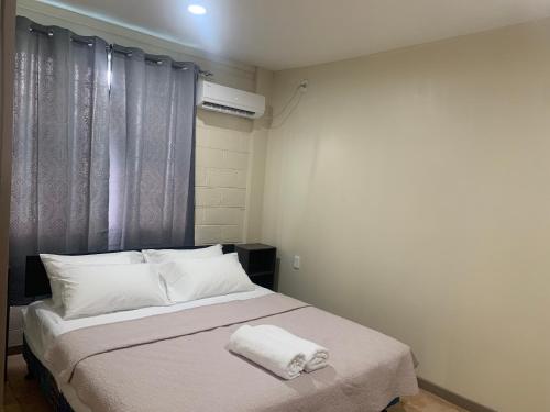 阿皮亚Samoa Business Apartments的一间卧室配有一张床,上面有两条毛巾