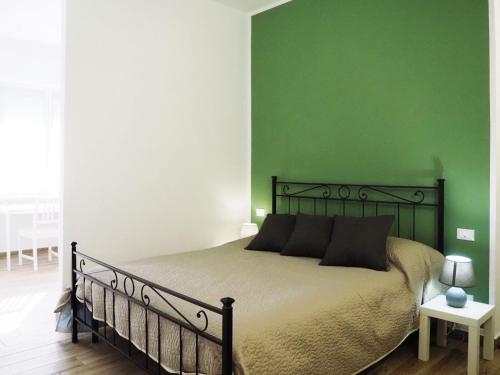 斯波托尔诺HOTEL RESIDENCE VILLA NINA的一间卧室配有一张带绿色墙壁的床