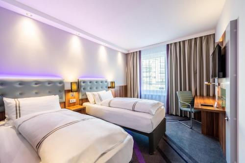 杜塞尔多夫Premier Inn Düsseldorf City Centre的酒店客房配有两张床和一张书桌