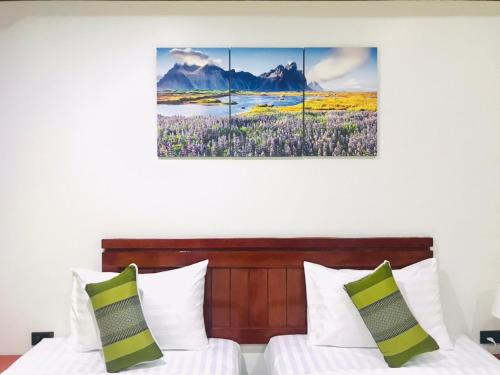 芭东海滩Benetti house的一间卧室设有两张床,墙上挂着一幅画