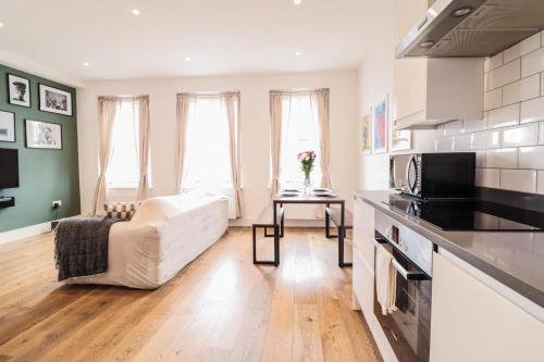 伦敦Modern & spacious 1 bedroom Clapham Junction flat的带沙发的客厅和厨房