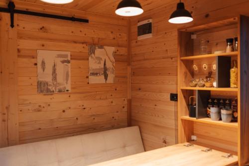 克利默内什蒂Tiny Heaven Cabin的配有木墙、长凳和灯的房间