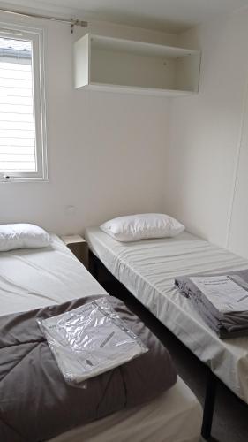 拉蒂尔巴勒Mobile home的两张睡床彼此相邻,位于一个房间里