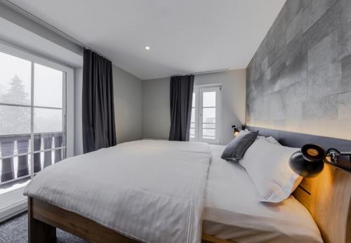 威拉尔-苏-罗伦Villars Lodge的一间卧室设有一张大床和一个大窗户