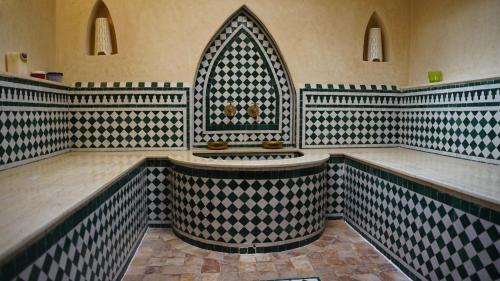 艾西拉casa bahia的一间铺有黑白瓷砖的客房内,浴室内设有大浴缸