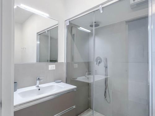 瓦拉泽Nuovo Bilocale con posto auto的白色的浴室设有水槽和淋浴。