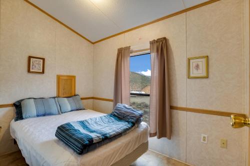 HierroThousand Trails Blue Mesa Recreational Ranch的卧室在窗户前配有一张床
