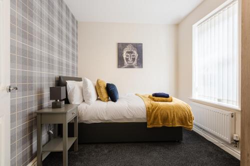 普雷斯顿Oxheys House - 5 Bedrooms Contractors Parking的卧室配有一张床铺,墙上挂着头骨照片