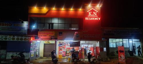 蒂鲁奇奇拉帕利KN residency, near Trichy Airport的一座肯塔基的金库建筑,晚上有人站在外面