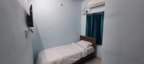 蒂鲁奇奇拉帕利KN residency, near Trichy Airport的一间小卧室,配有床和绿帘