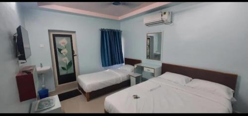 蒂鲁奇奇拉帕利KN residency, near Trichy Airport的酒店客房,设有两张床和镜子