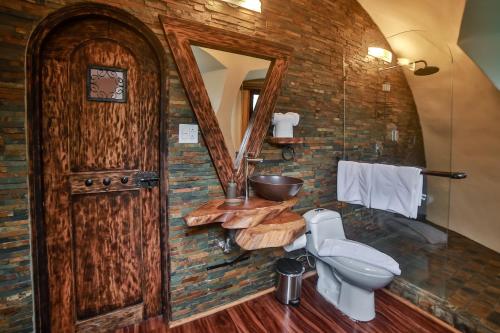 下博克特Bambuda Castle的一间带木门和卫生间的浴室