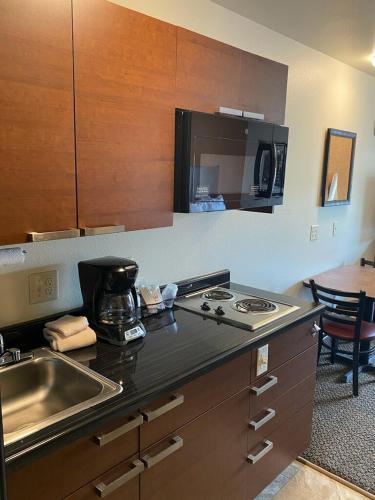 格林维尔Midtown Suites - Greenville的厨房配有水槽和炉灶 顶部烤箱