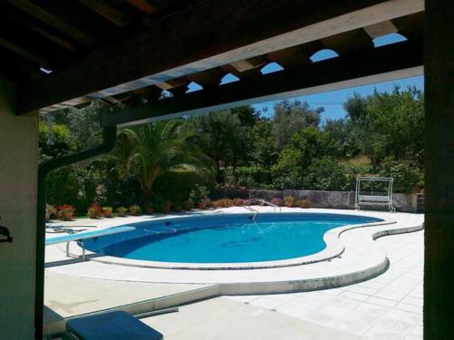 FagildeA Casa da Celeste的一个带遮阳伞的庭院内的大型游泳池