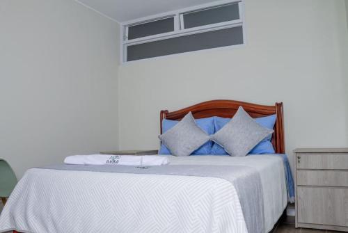 利马Departamento Amoblado的一间卧室配有一张带蓝色和白色枕头的床