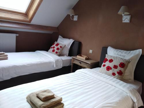 佐内贝克't Hooghe Licht Bed & Breakfast的一间卧室配有两张带毛巾的床