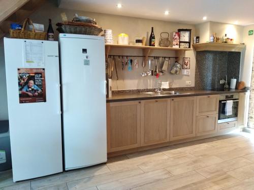 佐内贝克't Hooghe Licht Bed & Breakfast的厨房配有2台白色冰箱和木制橱柜。