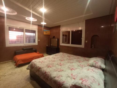 依索安Mubaradise Surf Hostel的一间卧室配有一张床、一张沙发和一台电视