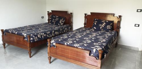 Dawwār Shindī FannūshZomoroda North Coast Chalet by Solid Pro的两张睡床彼此相邻,位于一个房间里
