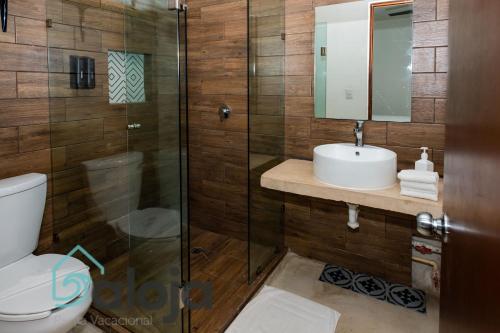 坎昆VIca Guest House con piscina en la entrada de la Zona Hotelera的浴室配有卫生间、盥洗盆和淋浴。