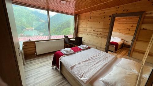 乌宗Kar Hotel Uzungöl的一间卧室设有一张床和一个大窗户